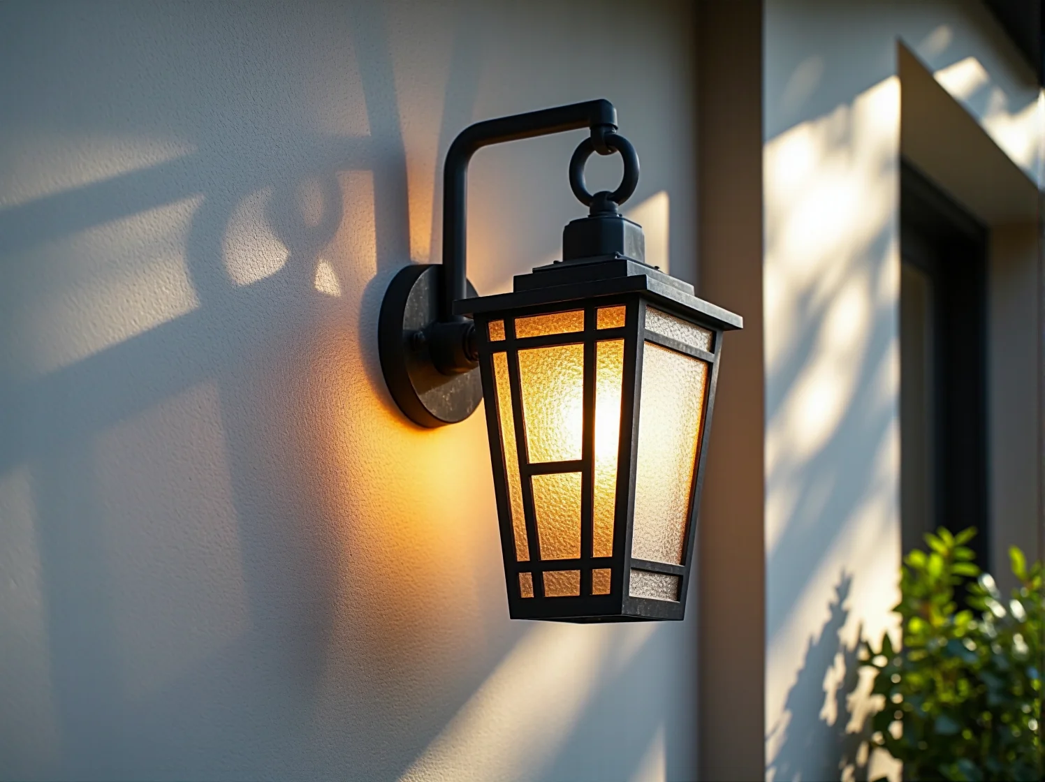 Złoty kinkiet zewnętrzny w stylu art deco zamontowany na ozdobnej elewacji domu.